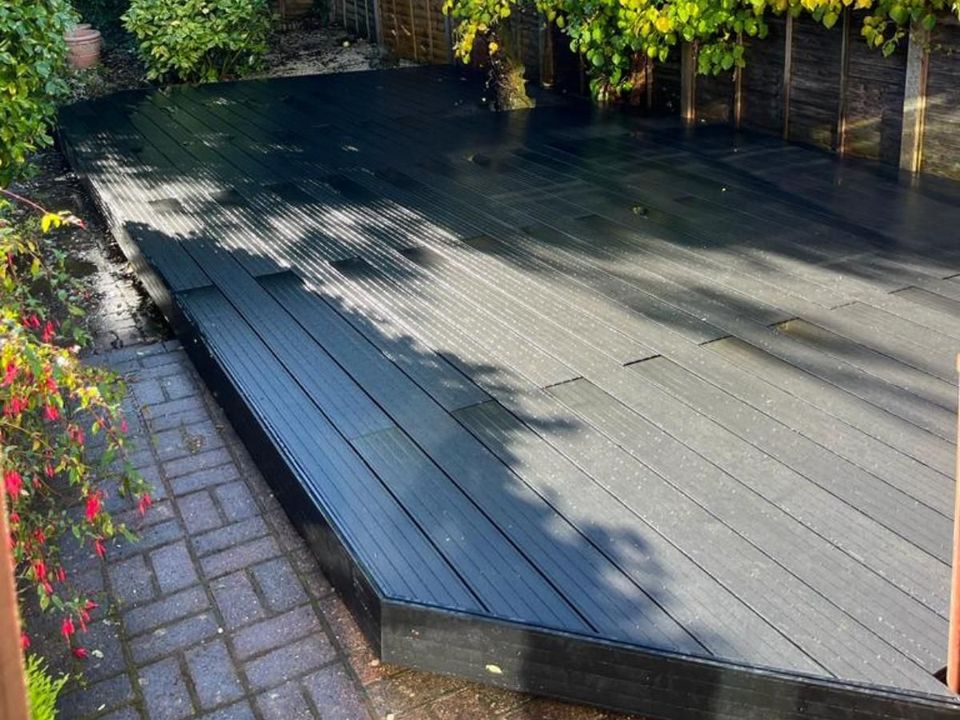 Grey composite deck boards beside a brick path
