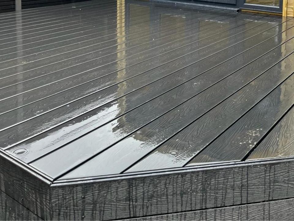 Close-up of a grey composite deck edge after rain