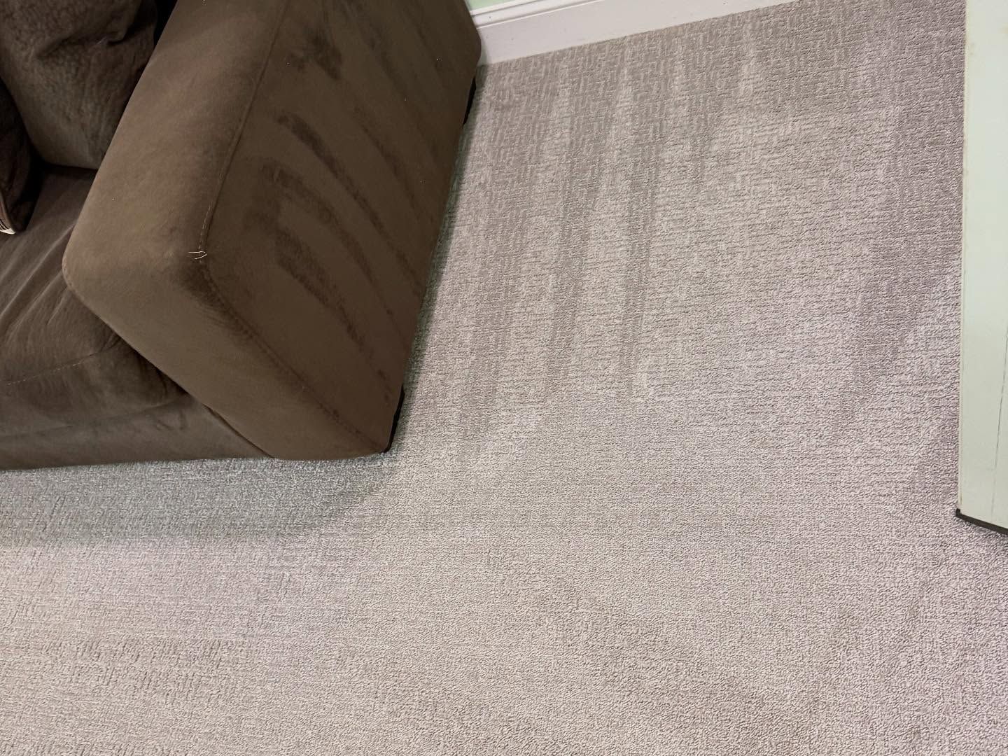 Brown couch on light gray carpet.