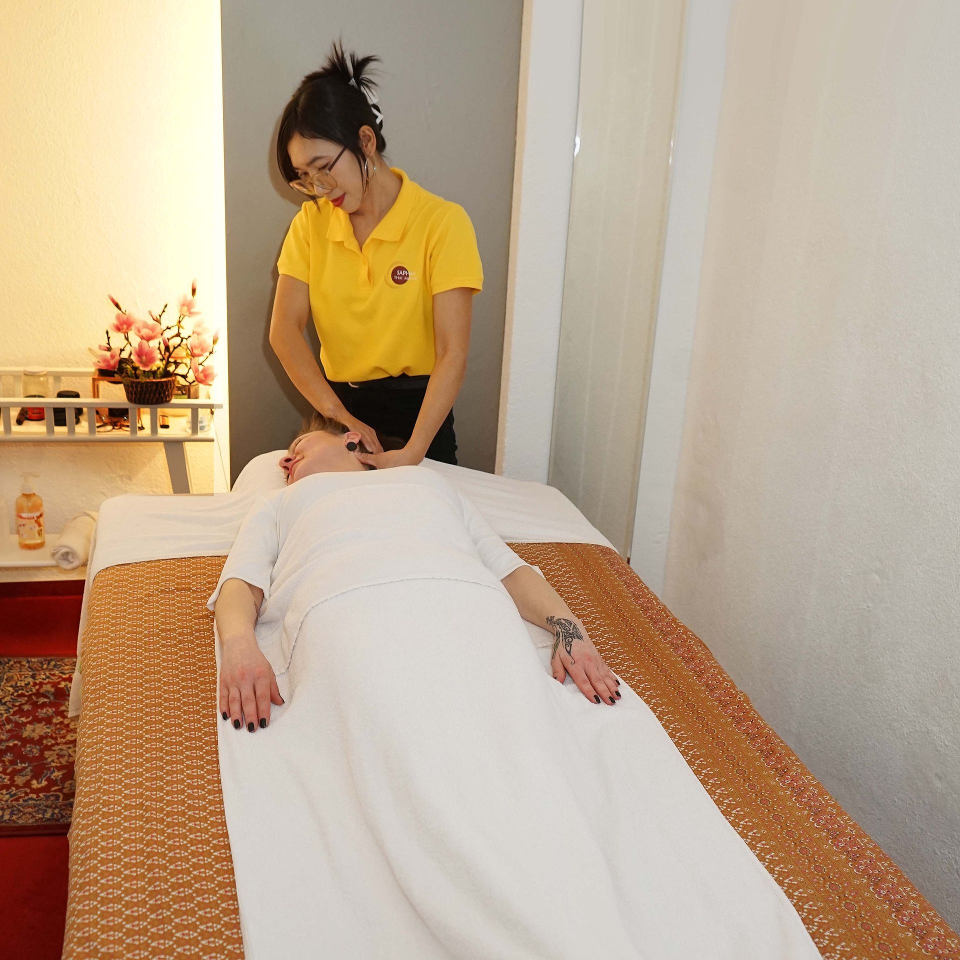 Eine Frau in einem gelben Hemd gibt einem Mann eine Massage