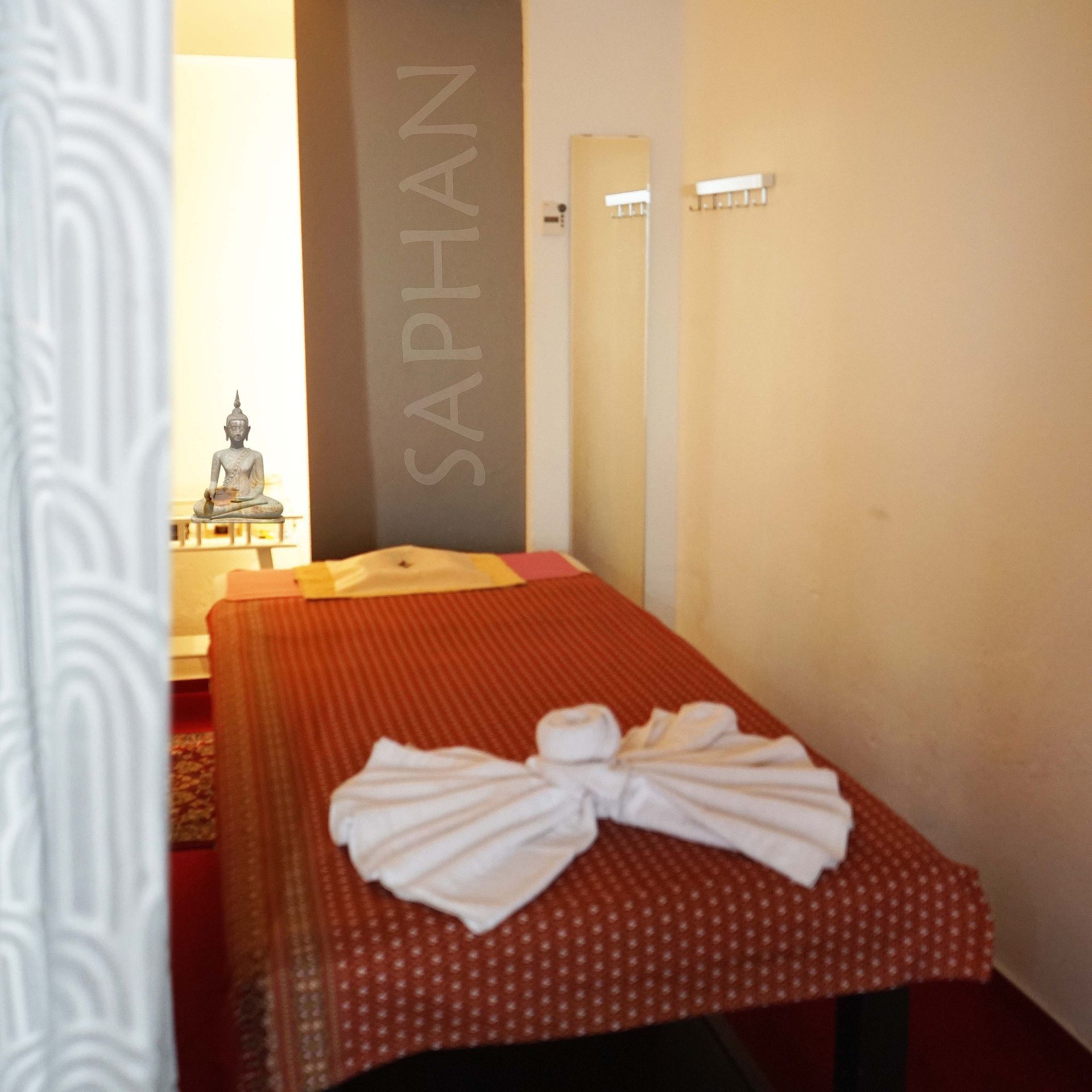 Ein Zimmer mit einem Bett und einer Wand, auf der Saphan steht