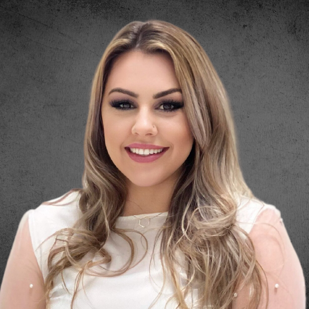 Smiling woman with long blonde hair in a white top against a gray background