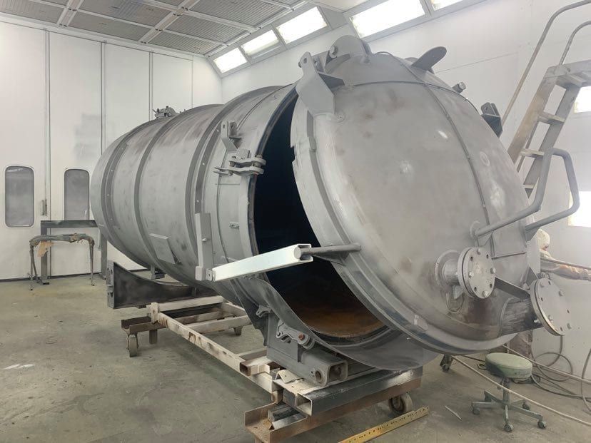 A large metal tank is sitting in a room with its door open.
