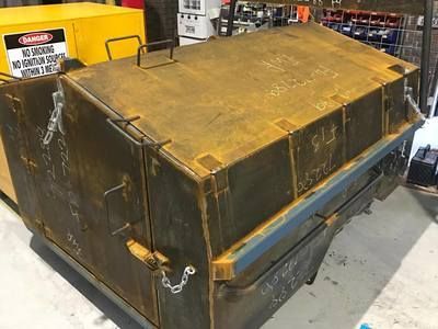 A rusty metal box is sitting on top of a table in a warehouse.