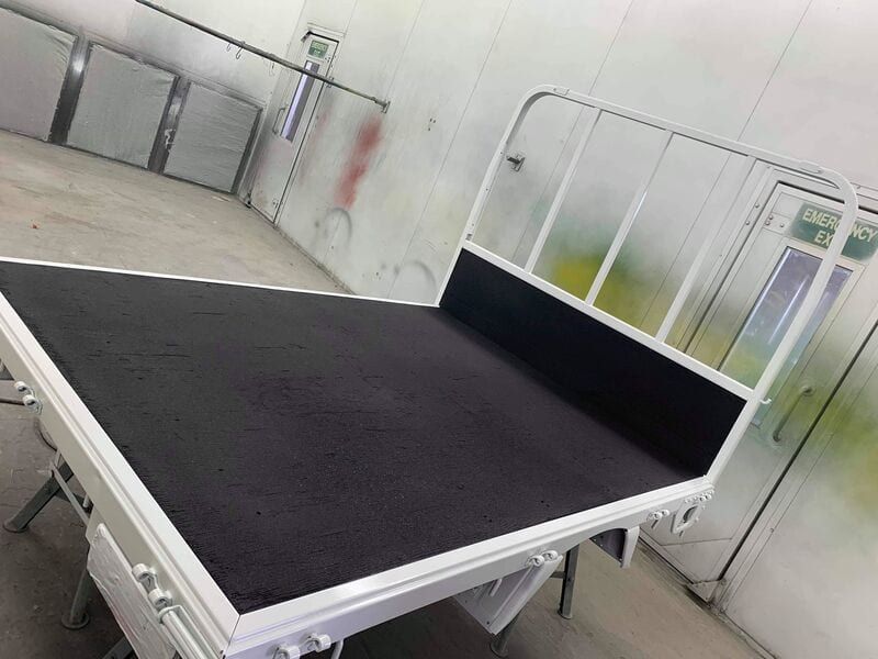 A bed with a black mattress and a white frame is sitting in a room.
