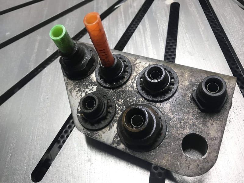 A piece of metal with a bunch of nuts on it