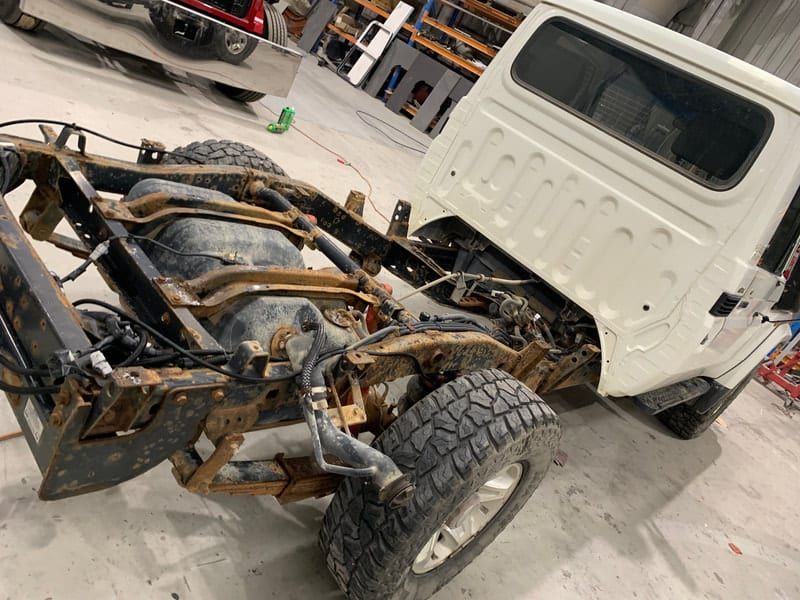 a white truck is being dismantled in a garage .