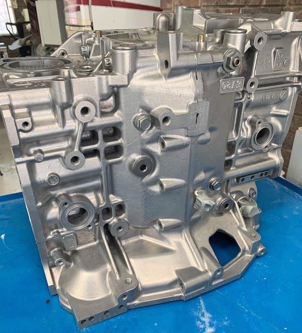 a stainless steel engine block is sitting on a blue table