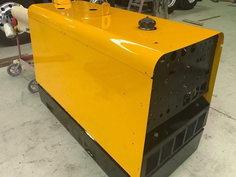 a yellow and black machine is sitting in a garage