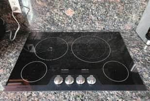 A black stove top oven is sitting on top of a granite counter.