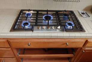 A gas stove is sitting on top of a kitchen counter.