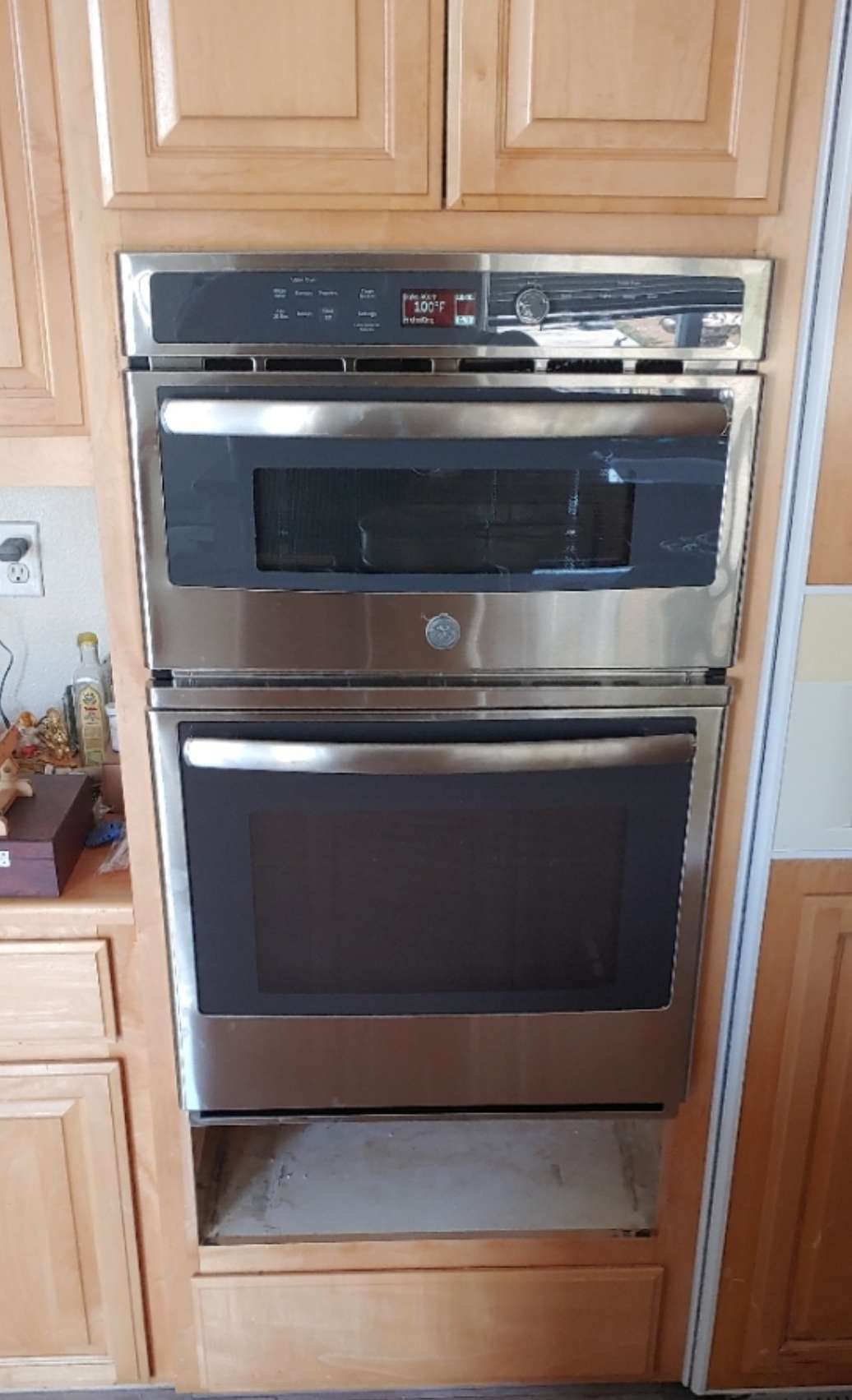 A stainless steel oven is built into the wall of a kitchen.