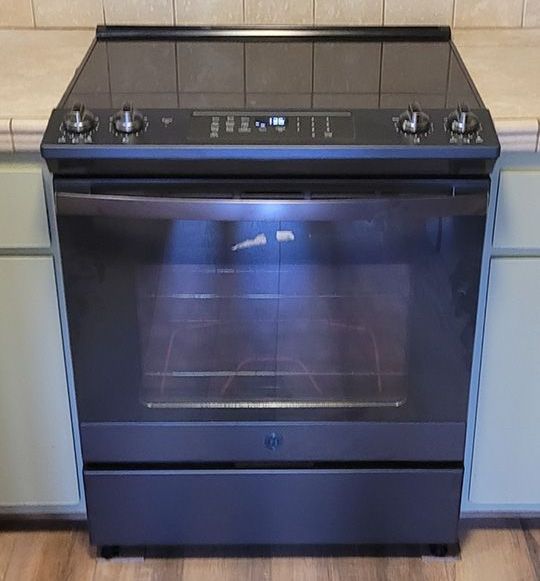 A black stove top oven is sitting on top of a kitchen counter.