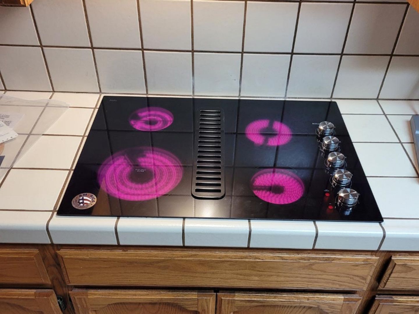 A black stove top with a pink light on it