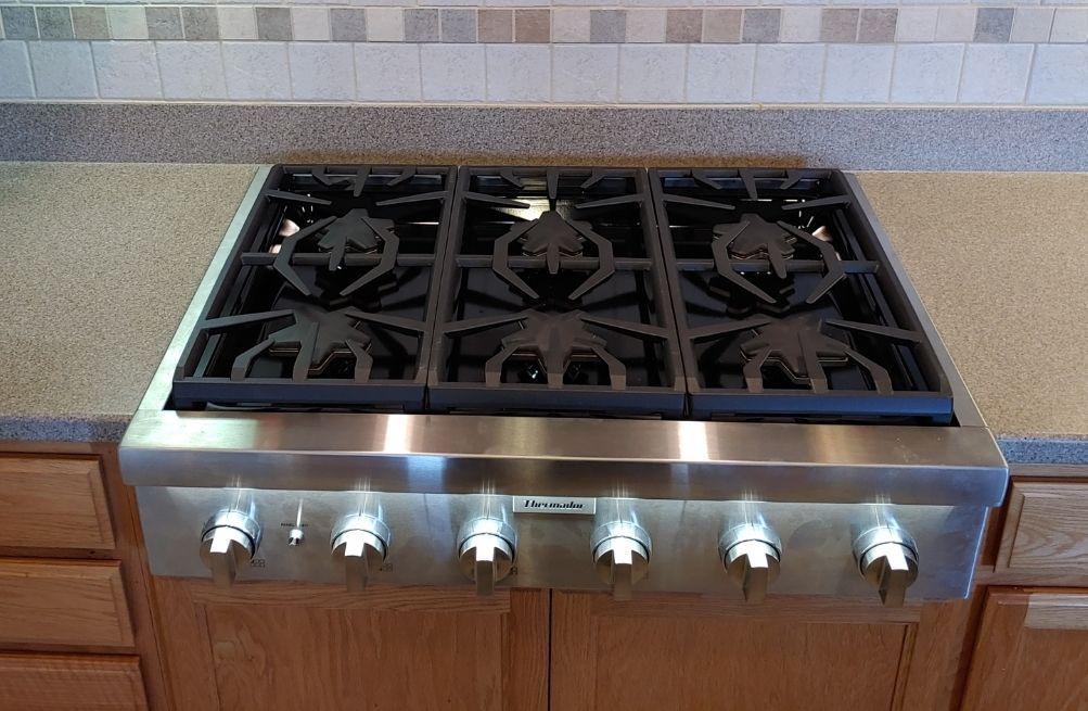 A kitchen with a stainless steel stove top oven