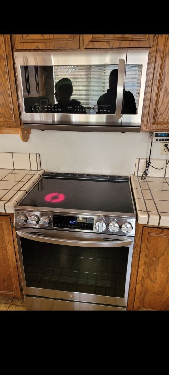 A stove with a microwave above it in a kitchen.