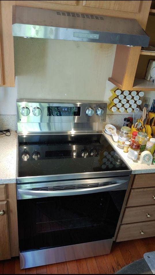 A stainless steel stove top oven is sitting in a kitchen.