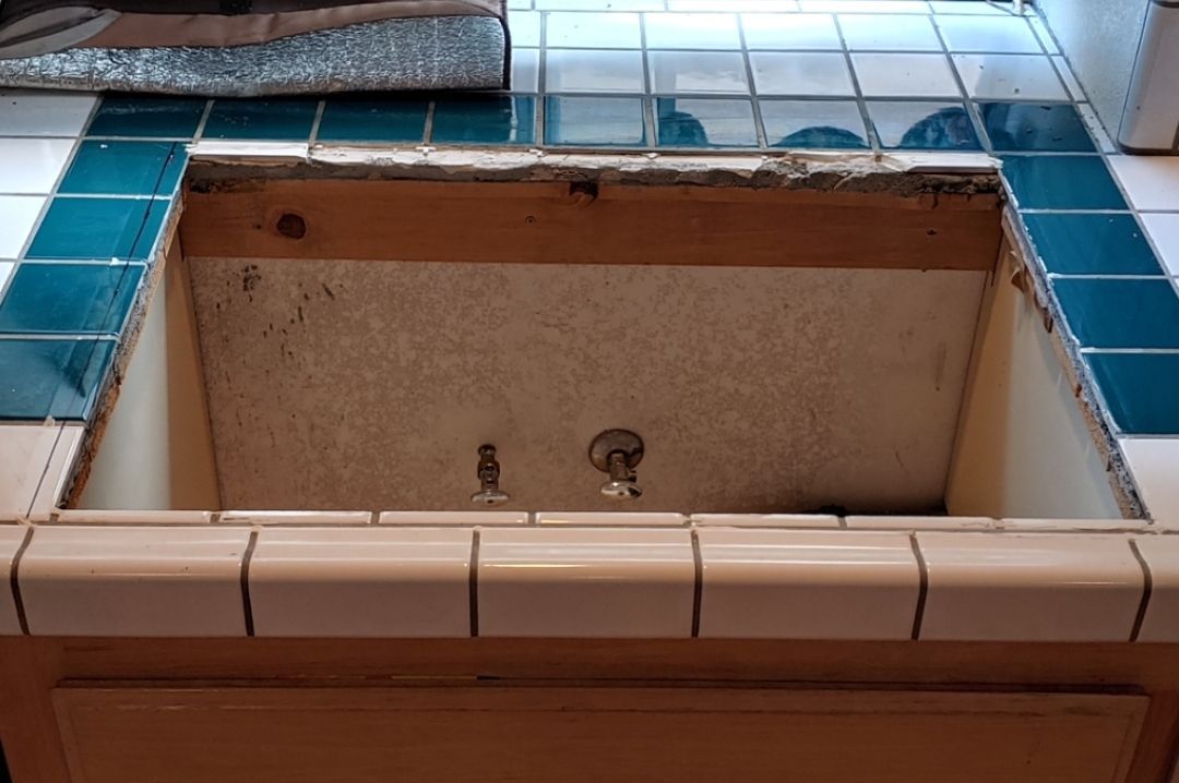 A kitchen sink with a hole in the counter top.