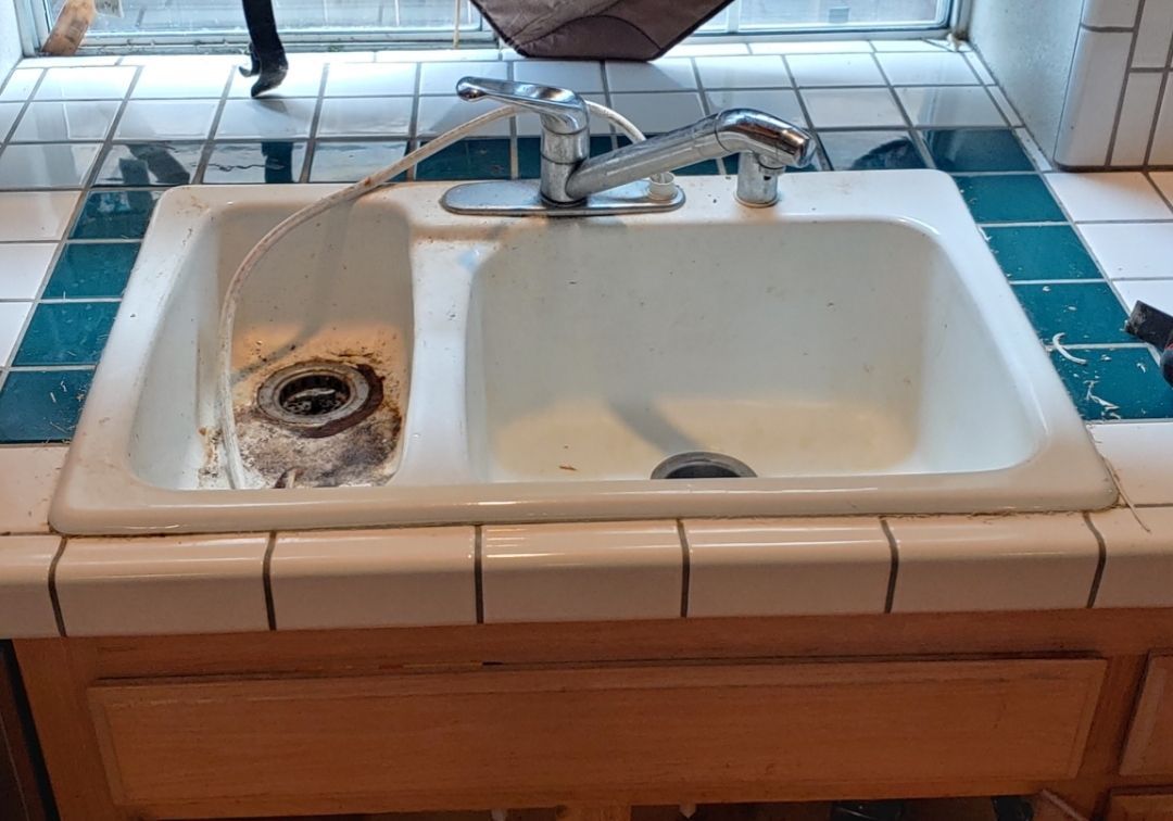 A kitchen sink with a hose coming out of it.