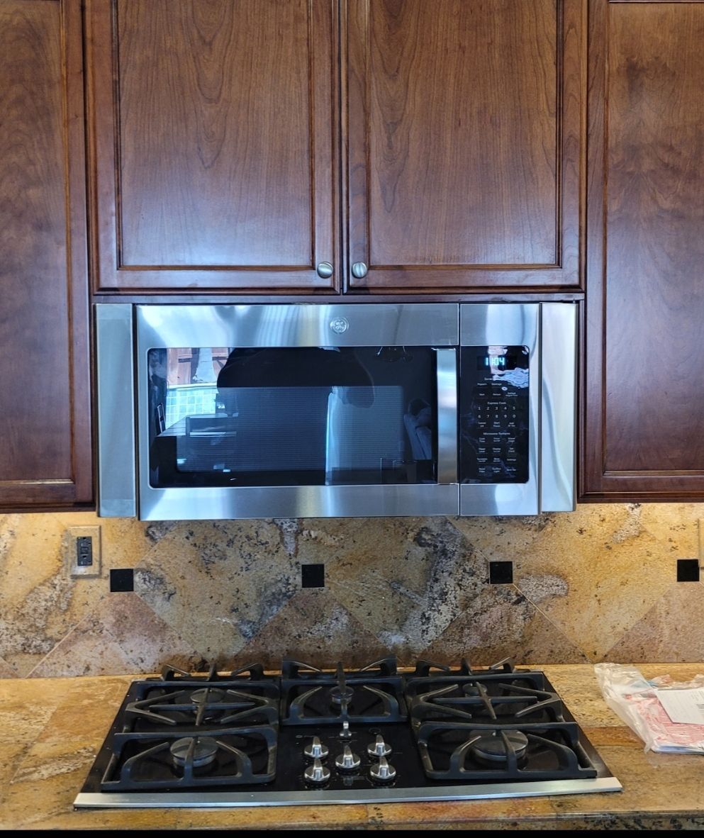 A stove top oven with a microwave above it