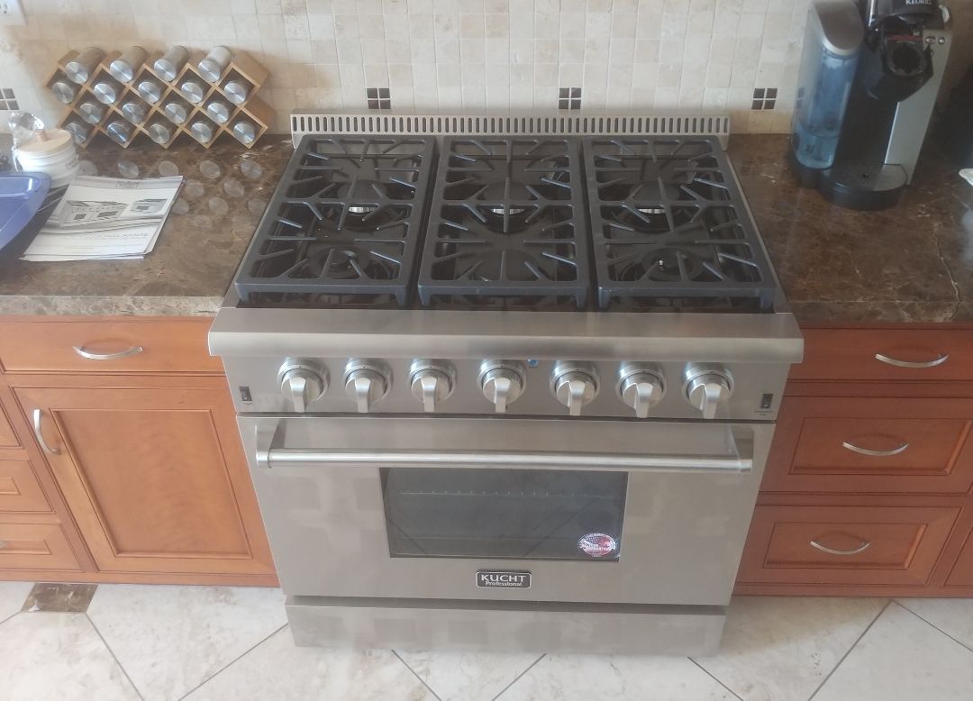 A stainless steel stove top oven is sitting on top of a kitchen counter.