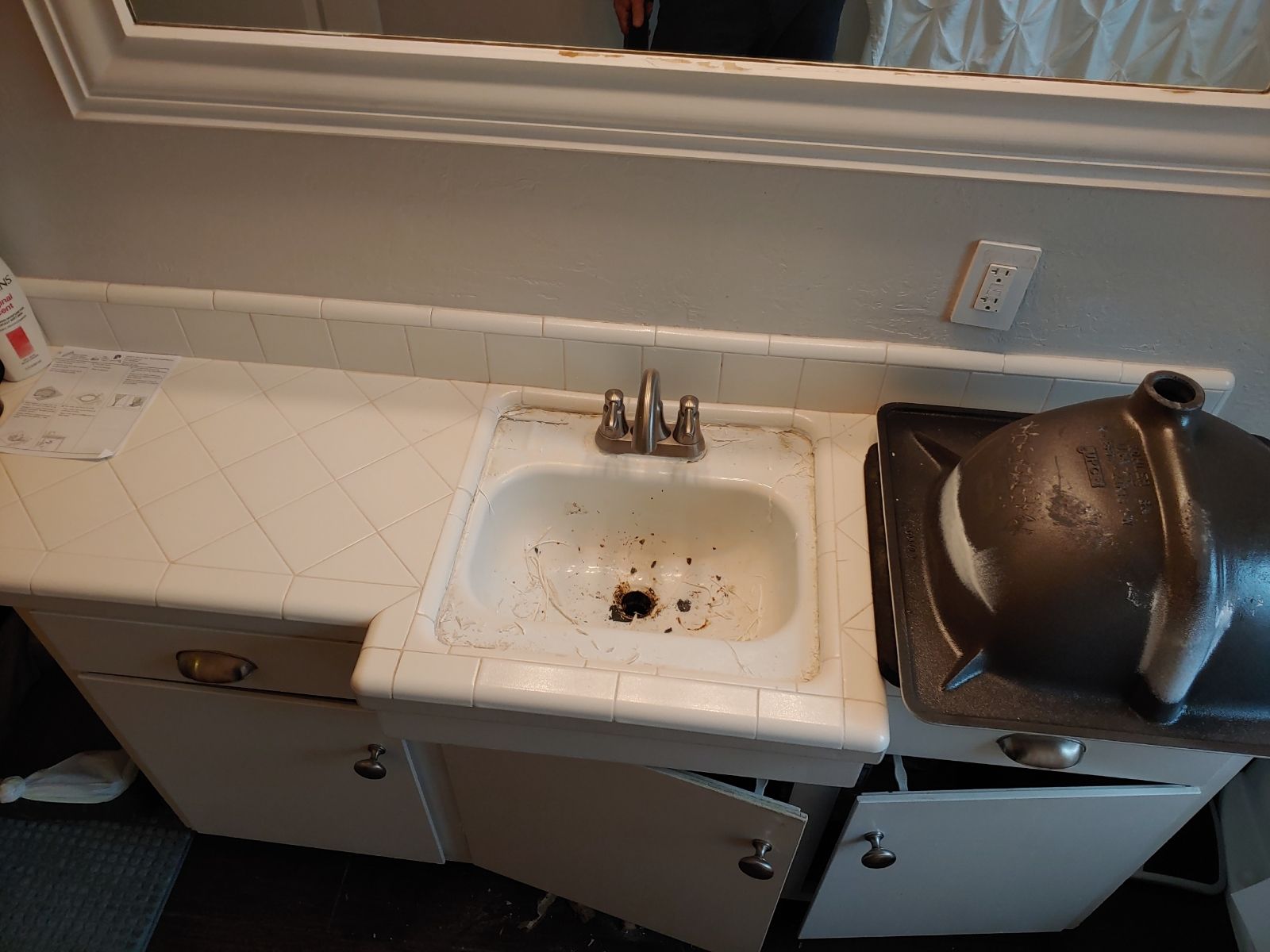 A bathroom with a sink , cabinets and a mirror.