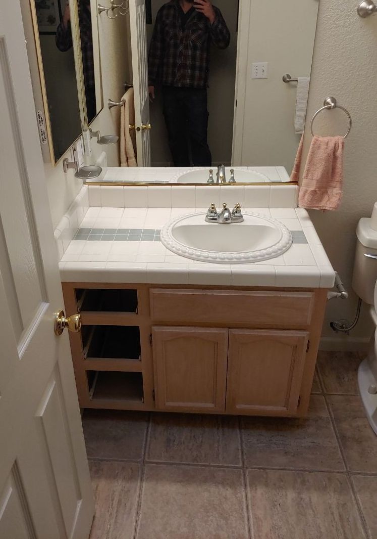 A bathroom with a sink , toilet and mirror.