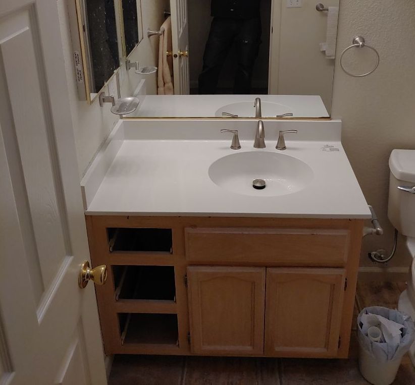 A bathroom with a sink a toilet and a mirror