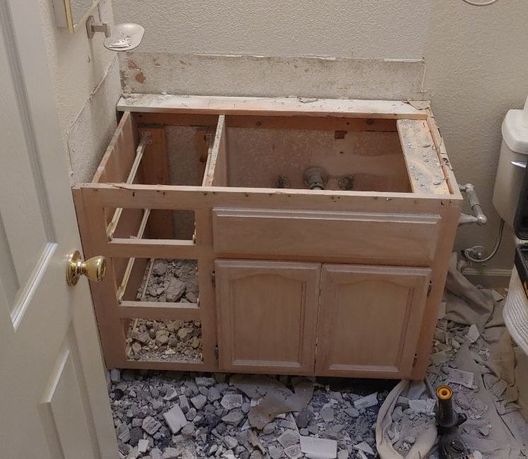 A bathroom vanity is being remodeled with a toilet in the background