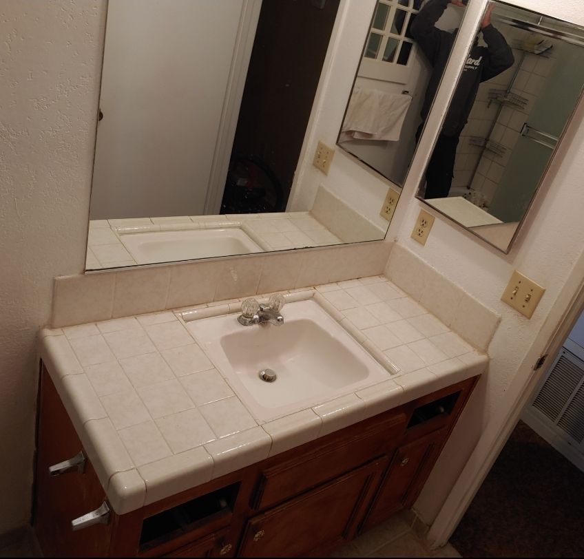 A bathroom with two mirrors and a sink