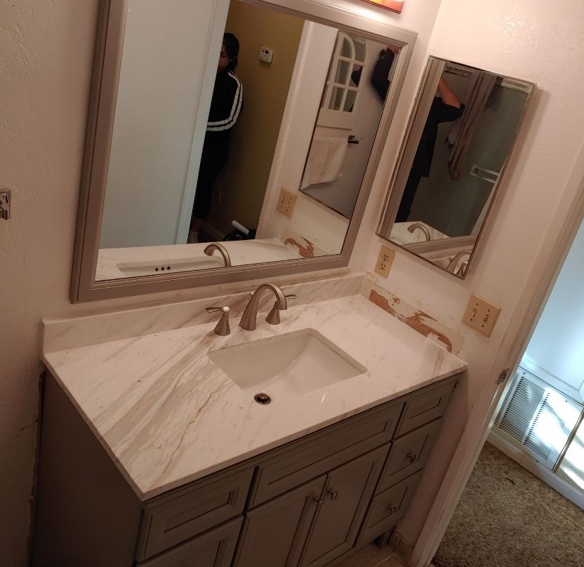 A bathroom with a sink and two mirrors
