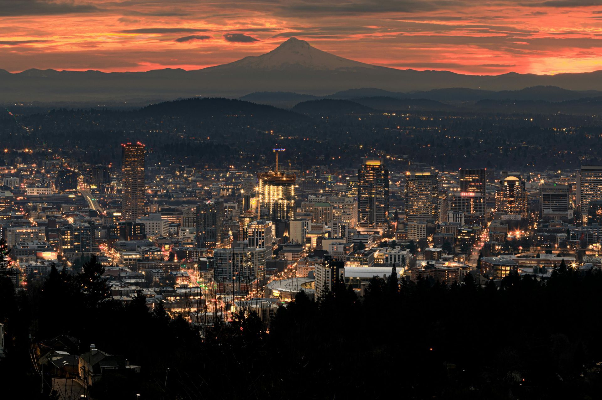 Mt Hood behind the Portland oregon city skyline with an orange sunrise sky