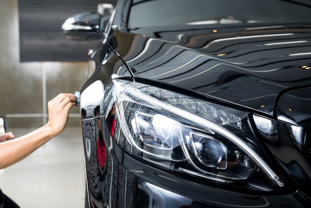 A White Van is Parked in a Parking Lot in Front of a Car Dealership — Platinum Hand Car Wash & Detailing in Belconnen, ACT