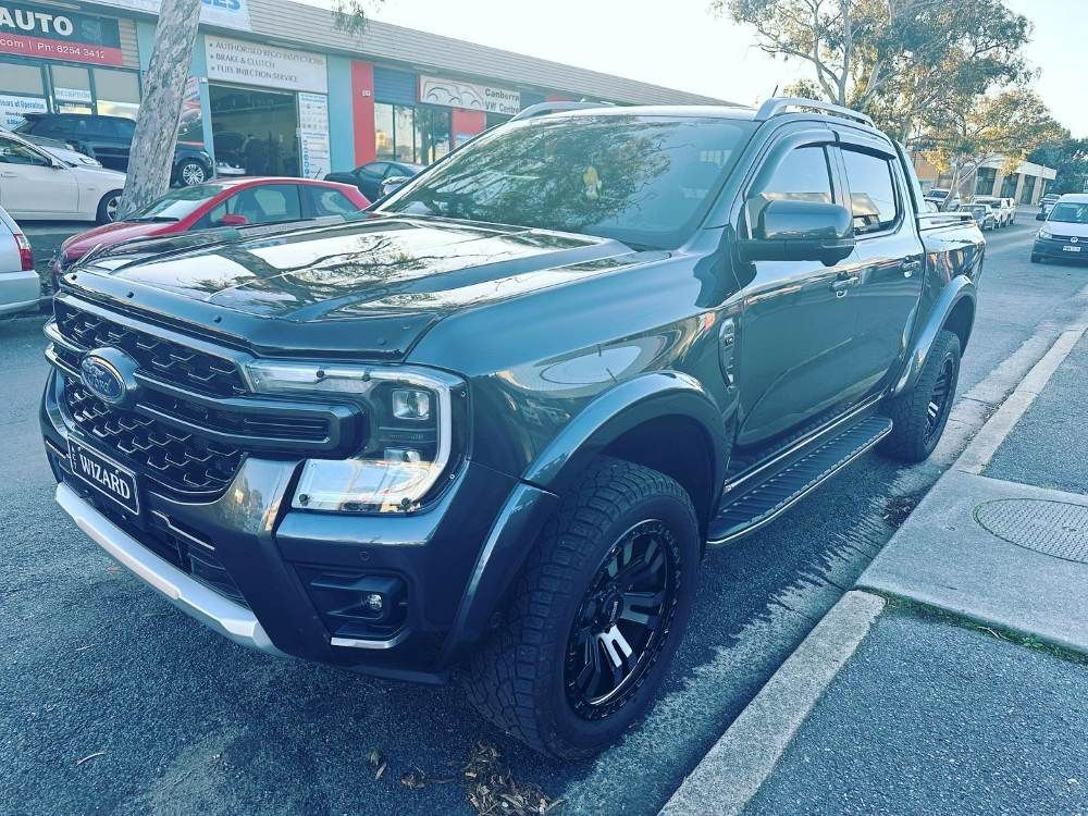 A Black Pickup Truck is Parked on the Side of the Road — Platinum Hand Car Wash & Detailing in Belconnen, ACT