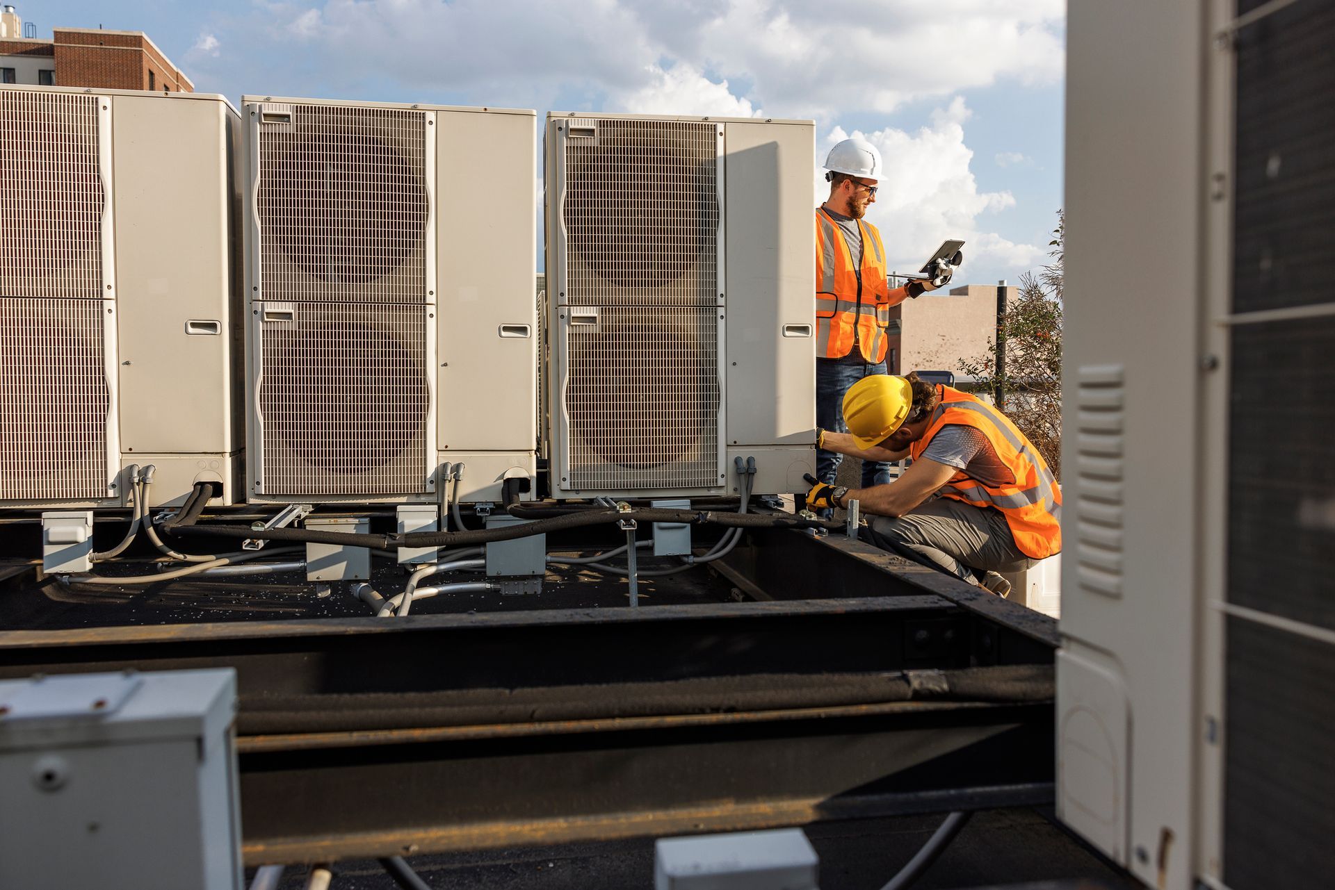 HVAC technicians inspecting and servicing rooftop commercial air conditioner in Powell, Tennessee.