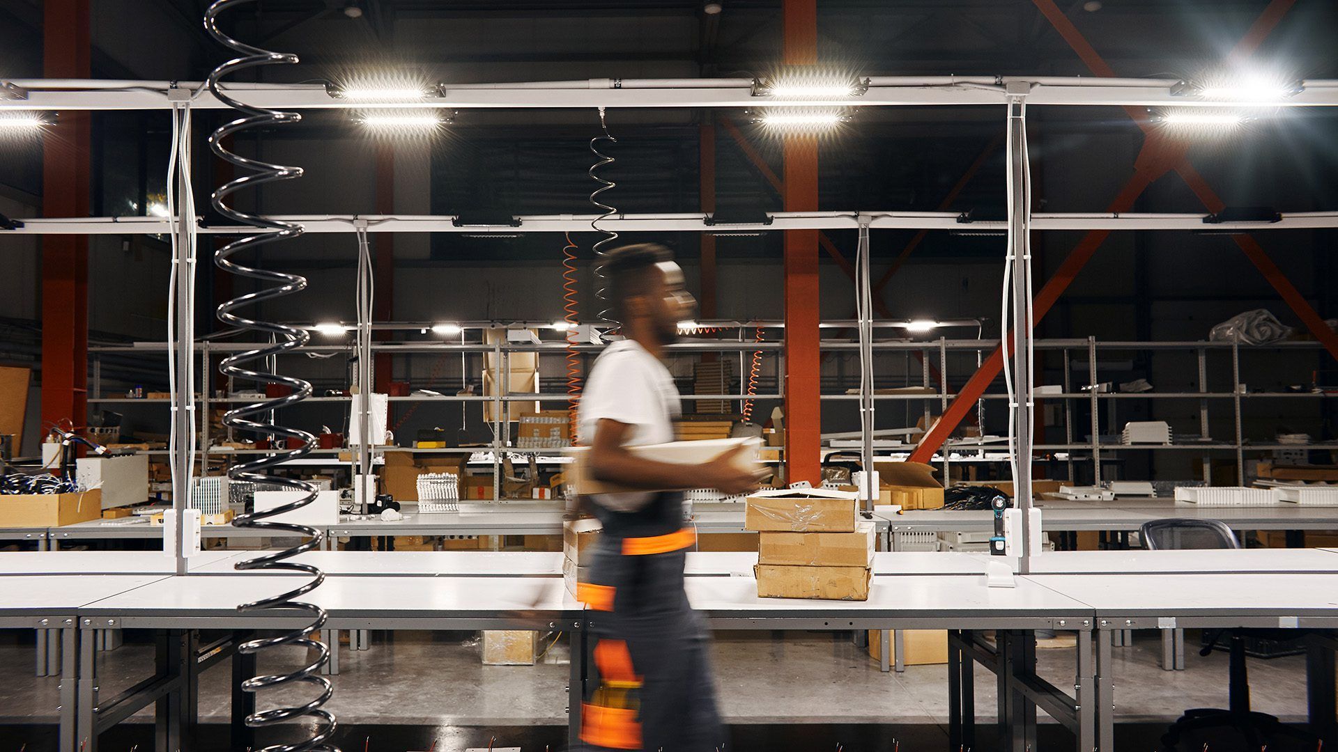 A man is standing in a warehouse holding a box.