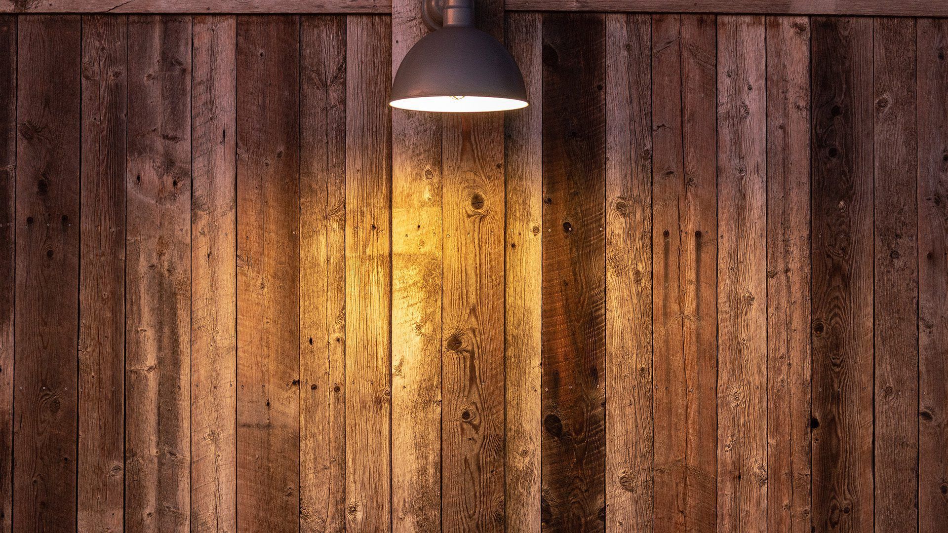 A lamp is hanging on a wooden wall.