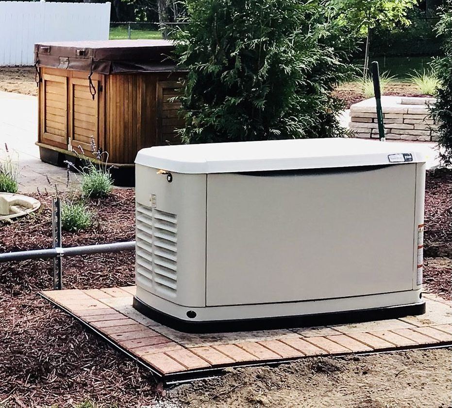 A generator is sitting on a wooden platform in a yard.