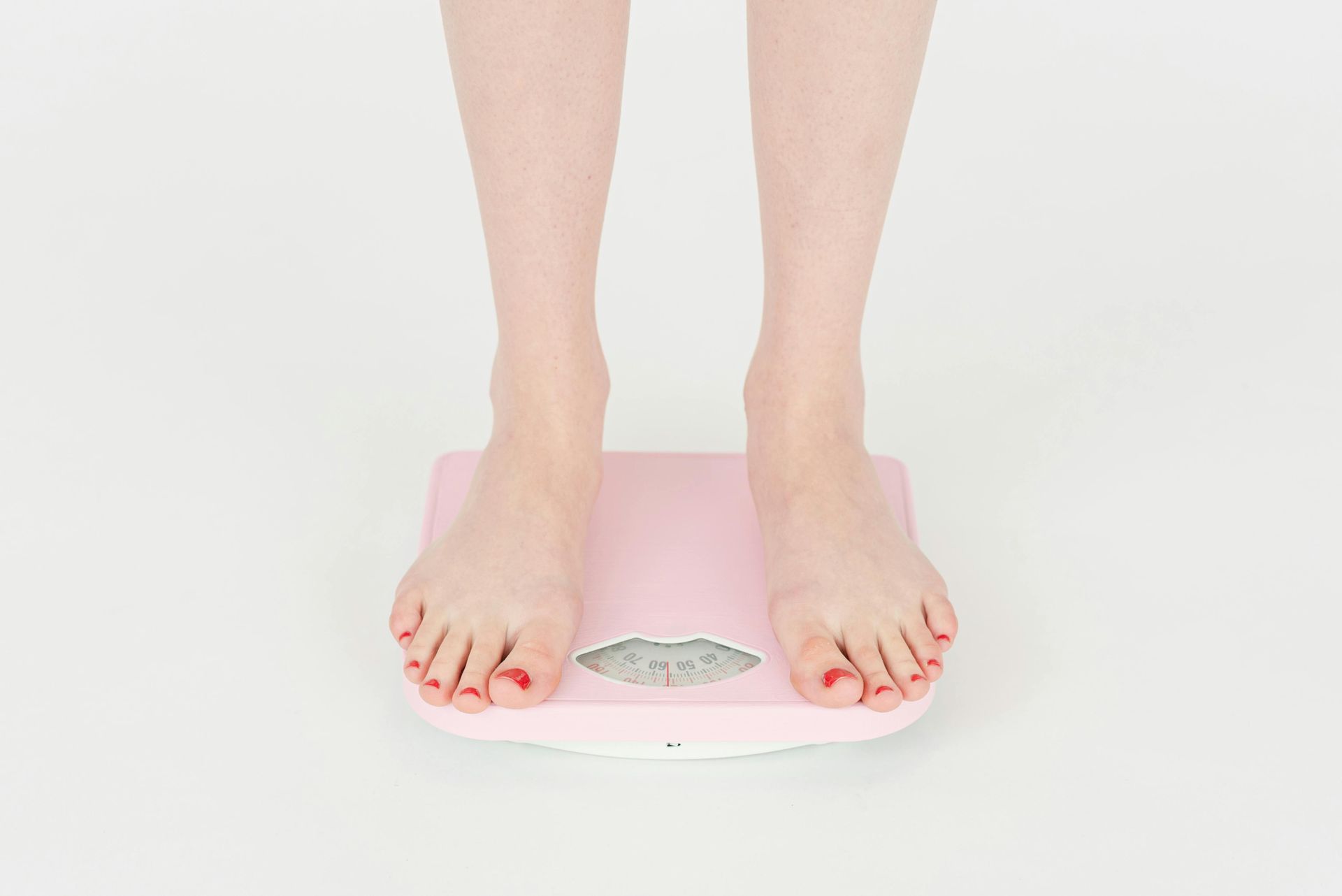 Person standing on a scale, measuring their weight