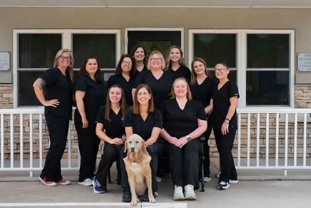 A group of women standing in front of a clover vet sign