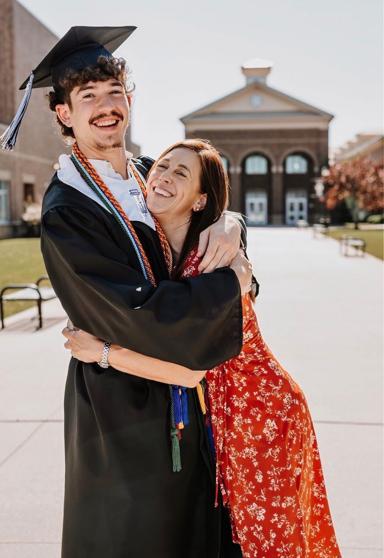 woman hugging young with cap and gown 