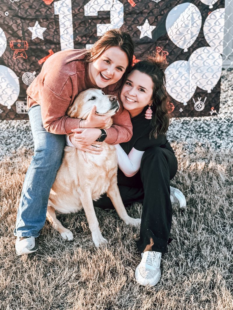 Two Clover vet employees hugging Breeze
