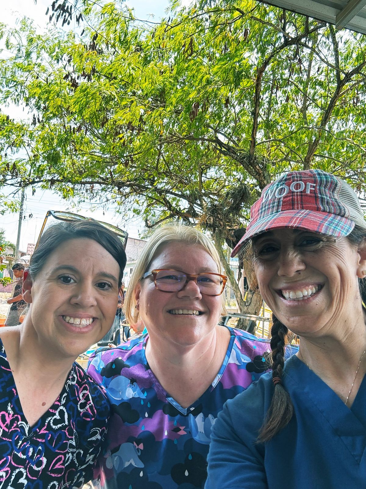 Lacie, Gretchen, and Allison are posing for a picture in front of a tree.