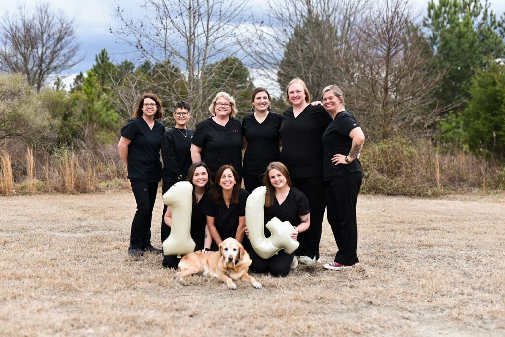 a group of women standing in a field with trees