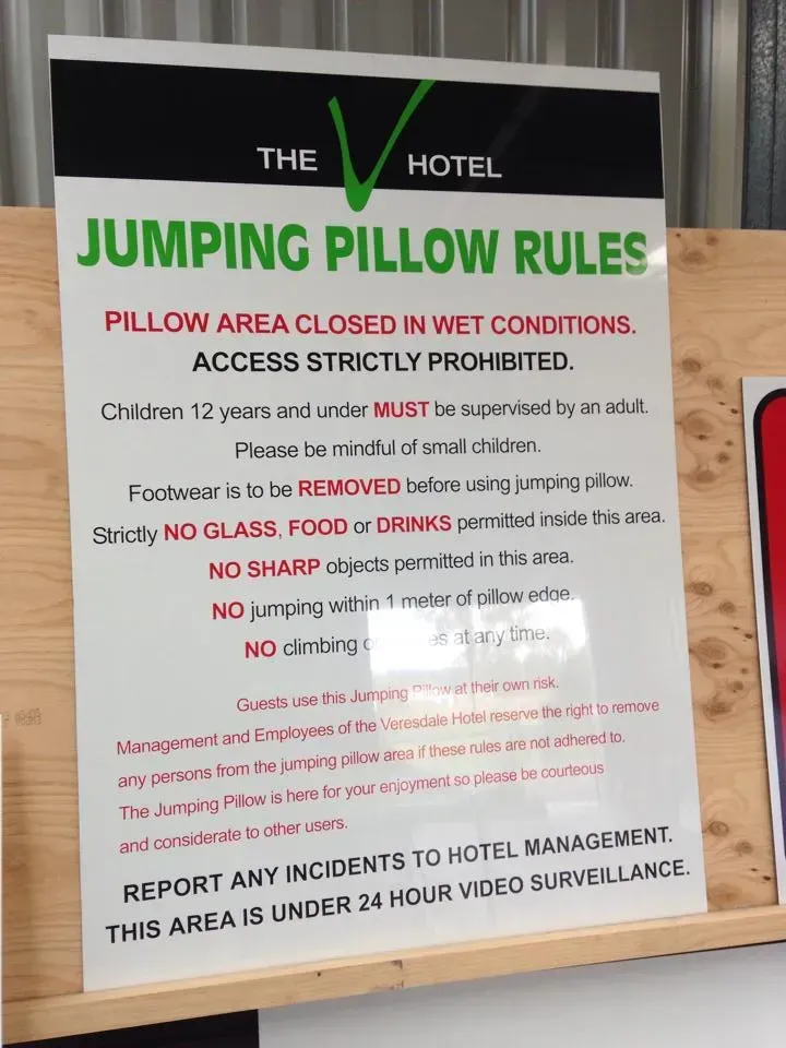 A sign that says jumping pillow rules on it
