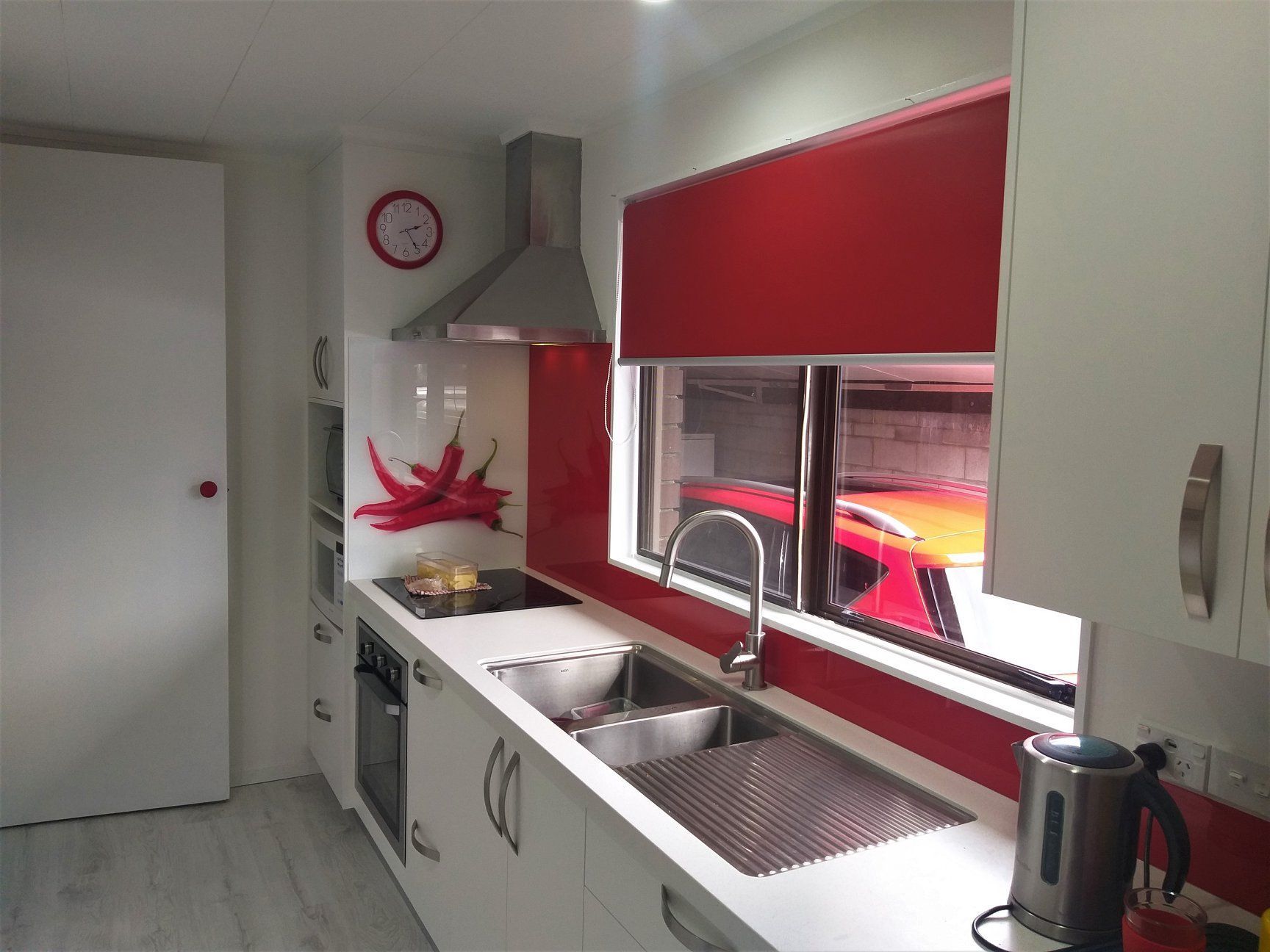 Modern kitchen with white cabinets, stainless steel appliances, and red accents. Modern kitchen with white cabinets, stainless steel appliances, and red accents.