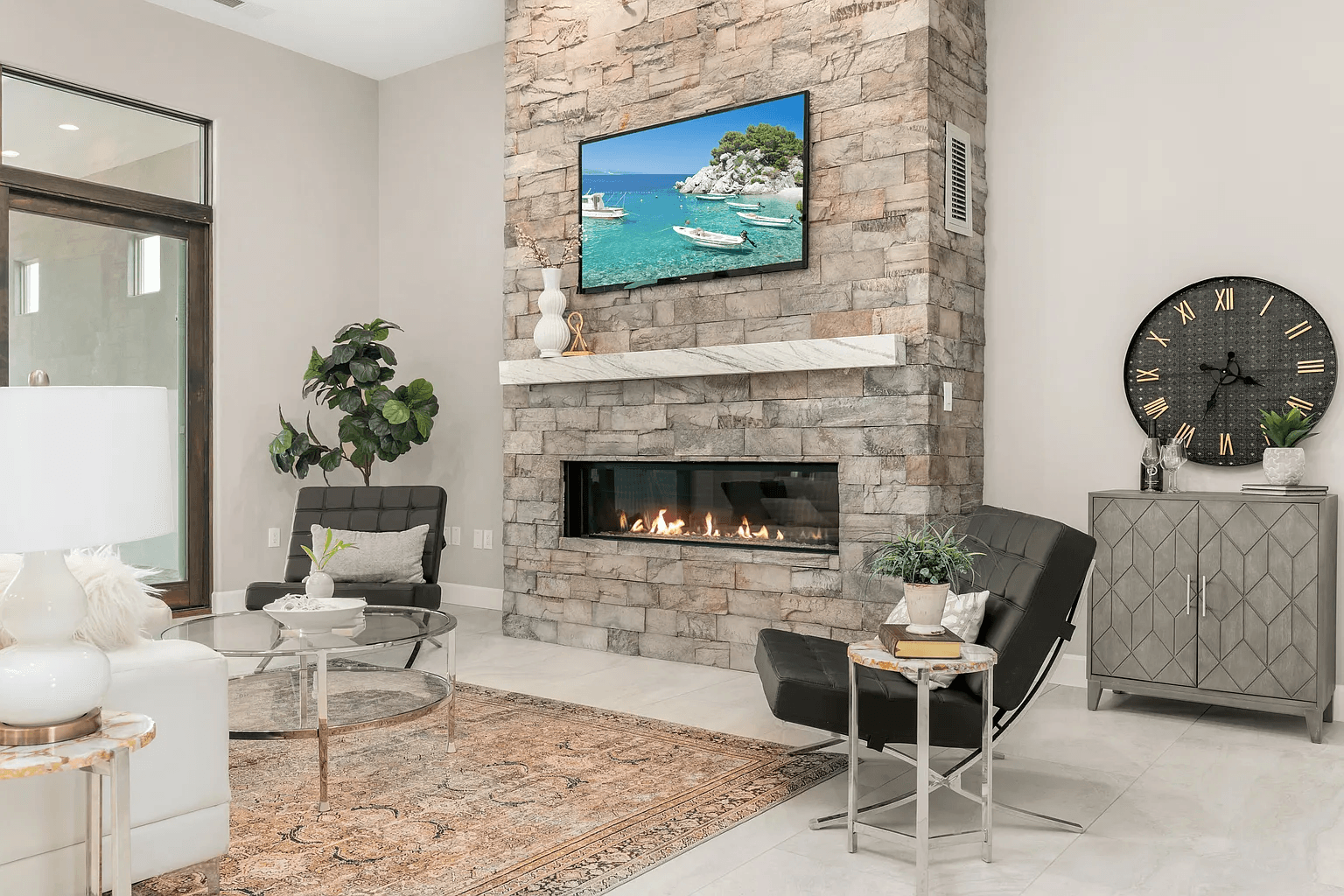 A living room with a fireplace and a flat screen tv on the wall.