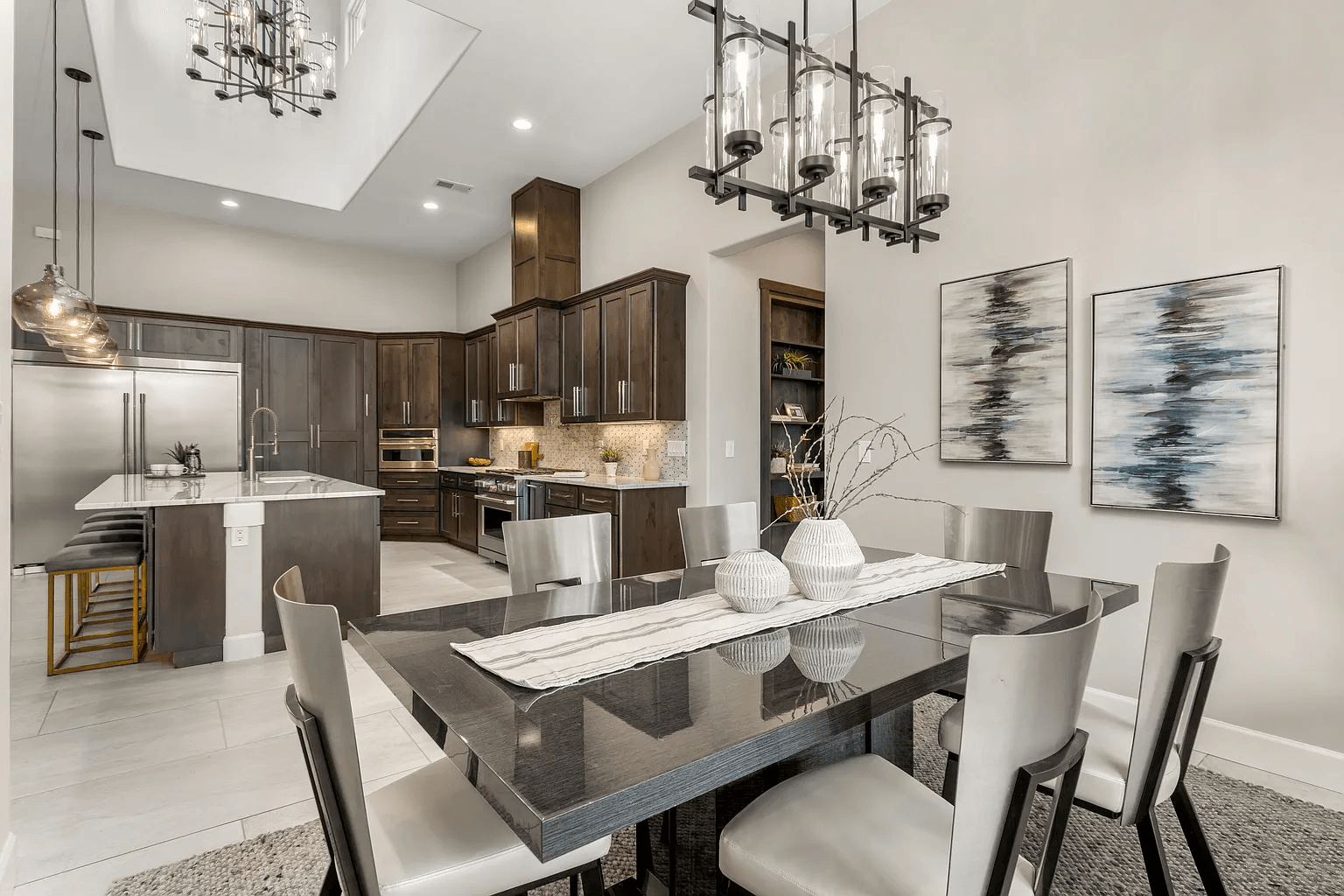 A dining room table and chairs in a kitchen with a chandelier hanging from the ceiling.