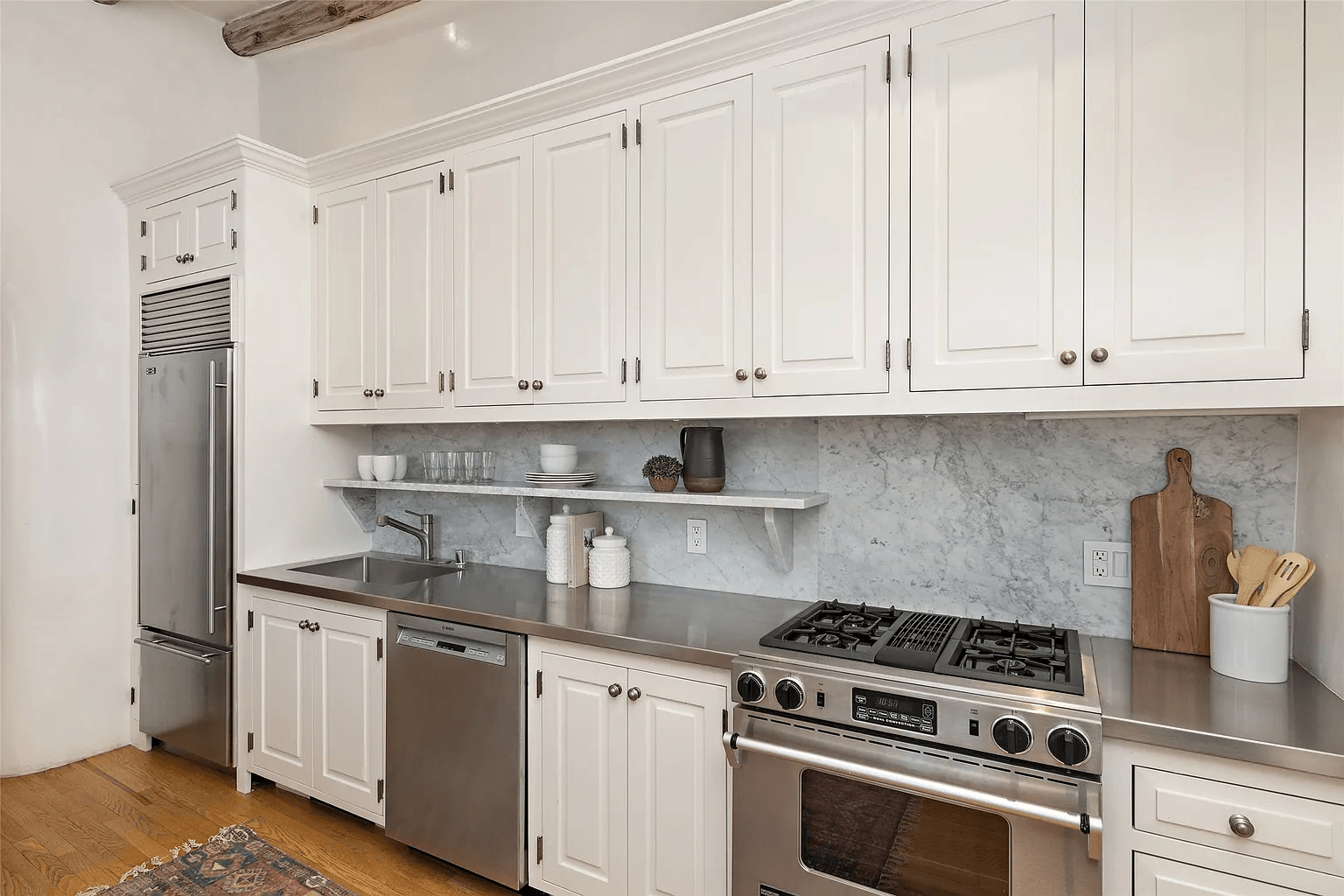 A kitchen with white cabinets and stainless steel appliances.