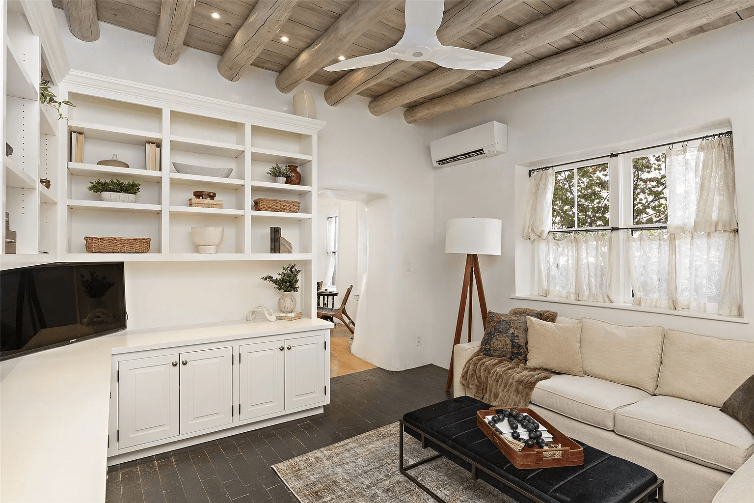 A living room with a couch , coffee table , and shelves.
